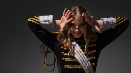 A glamorous blonde in a carnival uniform with epaulettes, posing with pretentious poses, a show...