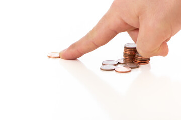 Man's finger moving pennies on white background with other coins. Concept of money movement and...