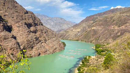 Naryn River in the rocky mountains of Kyrgyzstan. View of the amazing blue river. Beautiful summer landscape. Blue sky and white clouds.