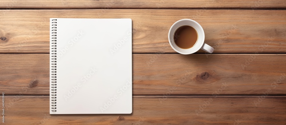 Poster notebook seen from above with coffee and light on wooden table