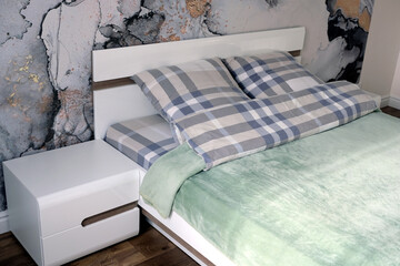 Bedroom in the house with double bed and nightstand in modern stylish interior in soft pastel colors