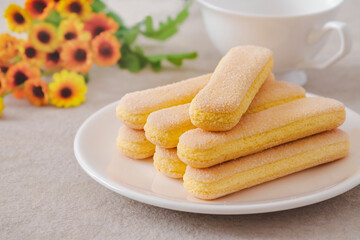 Lady finger biscuits, Italian dessert and sponge cookie on white plate and coffee cup