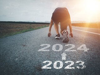 White arrow and text 2023 to 2024 on asphalt road A runner who is preparing to run forward entering the new year new beginning - obrazy, fototapety, plakaty