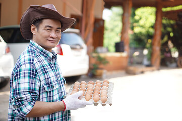 Handsome Asian man farmer holds tray of eggs from farm to sell and delivery to home. Concept,...