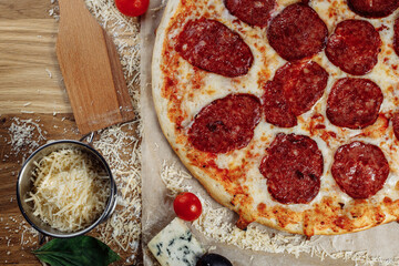 Pizza with chicken cheese and pepperoni, a piece of which is cut and laid out like a pakman, is on a wooden board and a brown background. Cheese spreads flowing streaks