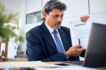 Contract, video call and businessman with a document in the office talking to an online client. Discussion, paperwork and mature professional male lawyer in a virtual meeting on a laptop in workplace