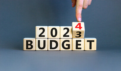 Planning 2024 budget new year symbol. Businessman turns a wooden cube and changes words Budget 2023...