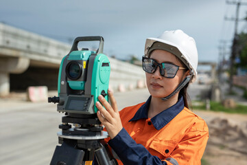 Portrait of Asian woman survey engineer standing with surveyors equipment (theodolite) at road...