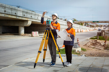 Two surveyor engineers working on road construction site