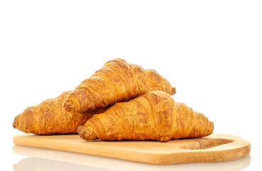 Three fragrant croissants with chocolate filling on a wooden board, close-up, isolated on white.