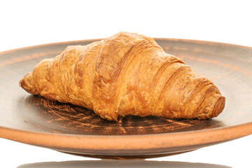 One fragrant croissant with chocolate filling on a plate of clay, close-up, isolated on white.