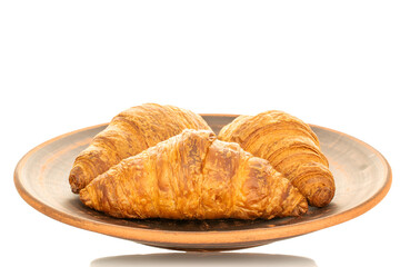 Three fragrant croissants with chocolate filling on a plate of clay, close-up, isolated on white.