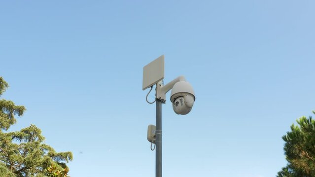 Modern surveillance camera. CCTV. Moving security camera on pole. Public place and streets security concept