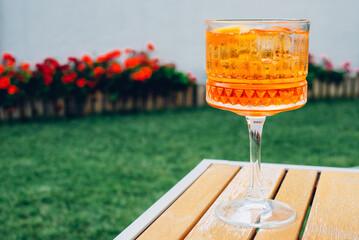 Glass of refreshing Aperol Spritz served outdoors on the terrace of modern bar. Popular Italian...