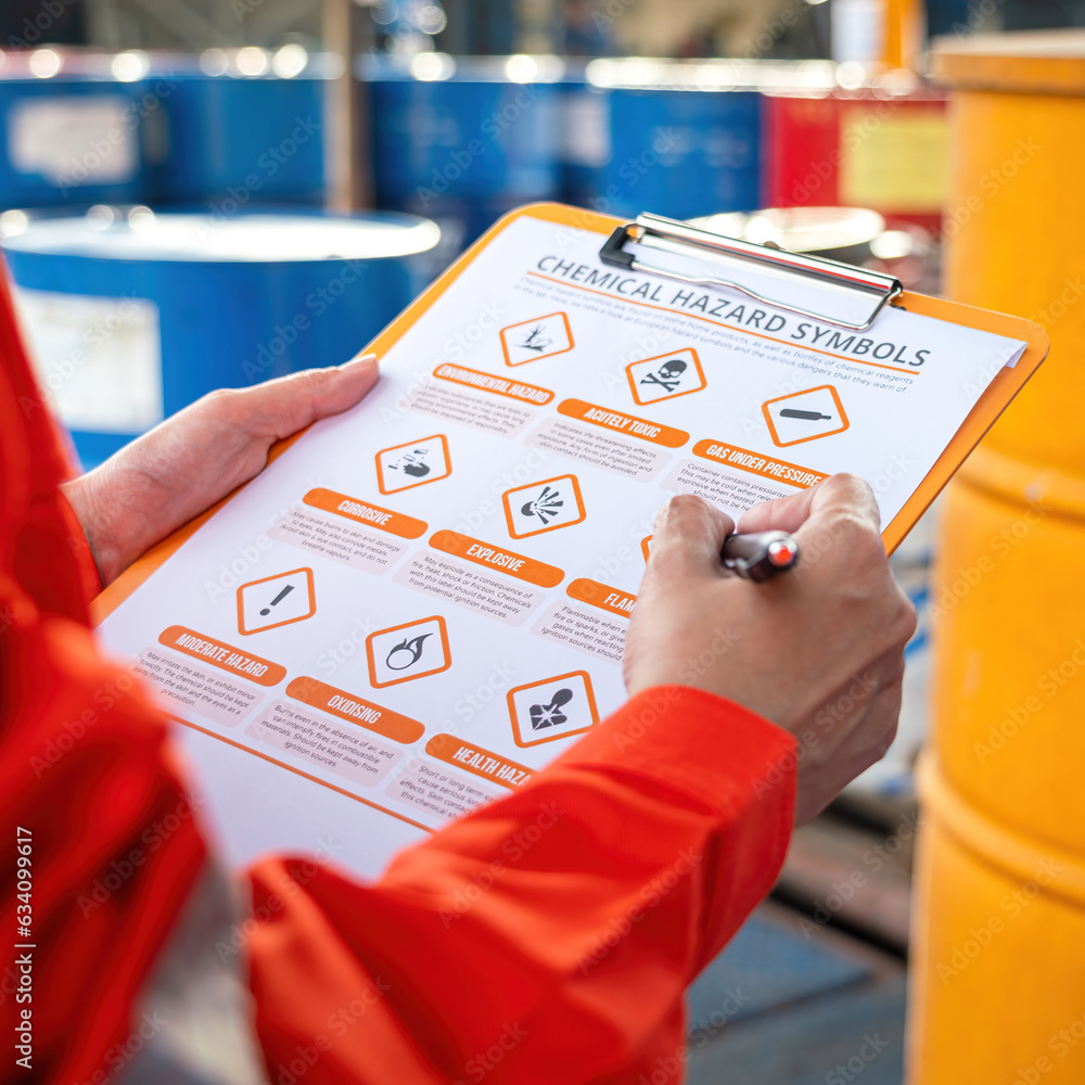 Wall mural action of safety officer is using a pen to checking on the hazadous material symbol label form with 
