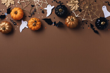 Halloween holiday background with party decorations from pumpkins, bats, spider web and ghosts top...