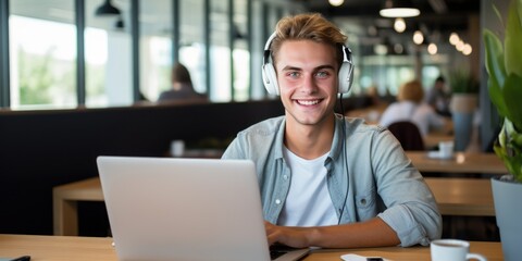 Smiling young intern businessman in headphones using laptop in creative office. Happy male student having online lesson watching or doing homework sitting, generative ai - obrazy, fototapety, plakaty