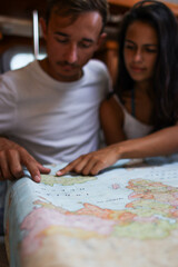 Fototapeta premium Vertical photo of young couple looking at the map their next destination