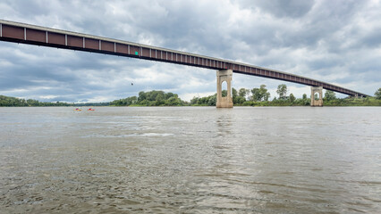 Fototapeta na wymiar two kayakers approaching a bridge over the Missouri River at Miami, MO