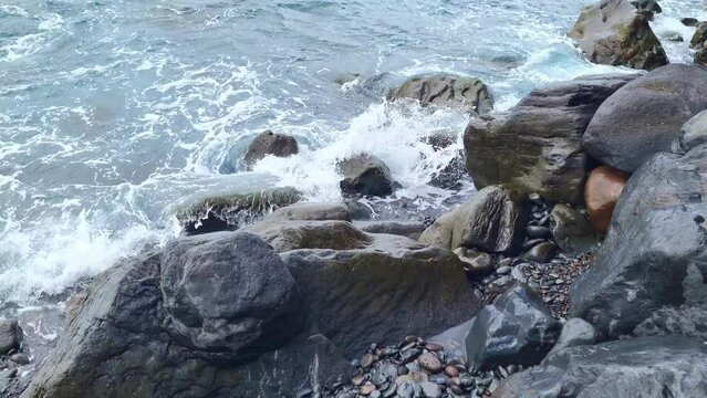 Large stones on the seashore wash the wave