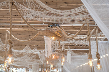 rope hanging light bulbs and white thread net on bamboo ceiling
