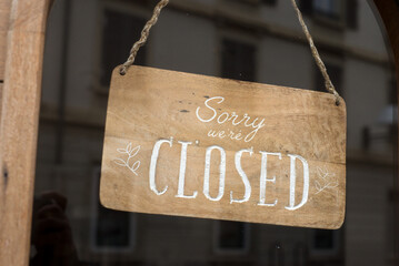 Closeup of sorry we are closed panel in a fashion store entry in the street - 634125485
