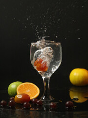 Mixed fruits splashed on wine glasses