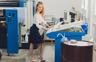 Young woman working in printing factory. Printing Press.