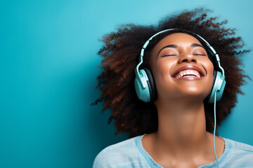 Young cheerful african american woman with curly hair listening to the music on the headphones. High quality photo - Powered by Adobe