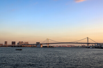 夕方の東京湾話を走る水上バスとレインボーブリッジ