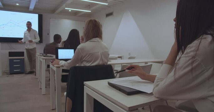 Experienced couch giving lectures to employees in the start up company in the education center, trucking motion