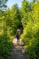 Fototapeta na wymiar Hikers on Shi Shi Beach Trail in Olympic National Park near Neah Bay, Washington on sunny summer afternoon.