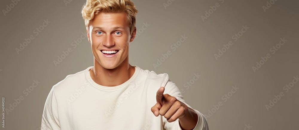 Poster cheerful young man pointing happily to object in copy space