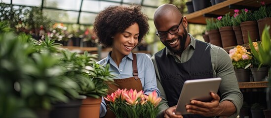 Multicultural plant nursery workers using tablet and drinking coffee