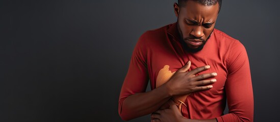 Distressed young African man clutching chest health emergency available area for text