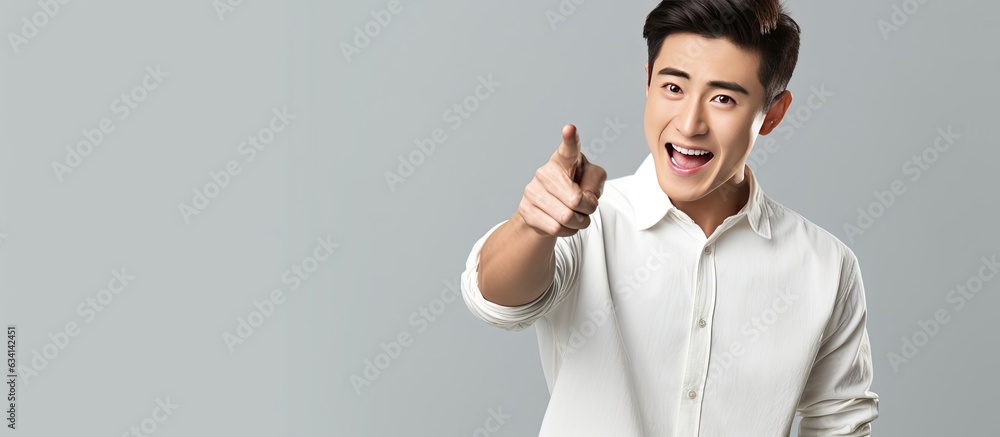 Sticker asian man wearing white shirt is shocked and pointing right with surprise on gray background with sp