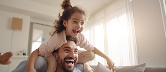 Middle eastern family playing together at home cheerful dad lifting up his joyful girl playing airplane copy space