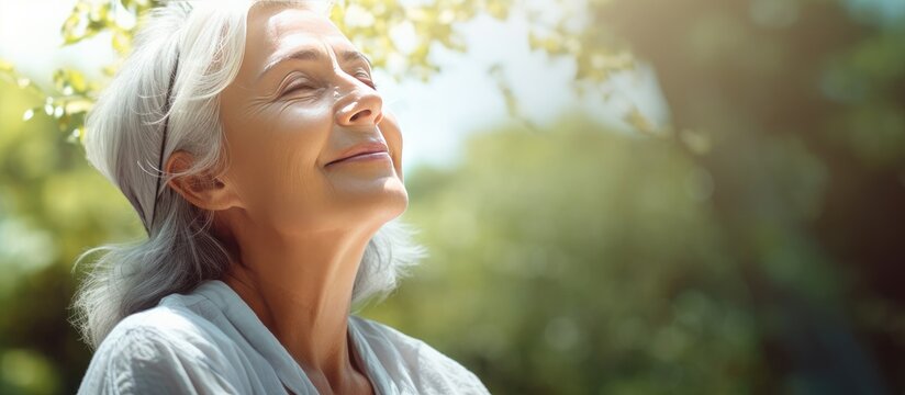Elderly woman s portrait in park enjoying fresh air and sunlight Promoting healthcare and wellness