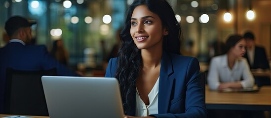 An Indian Asian girl searching for job opportunities online using a laptop