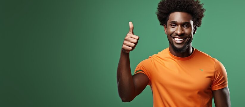 Happy African man at the gym pointing and smiling wearing sports attire with curly hair
