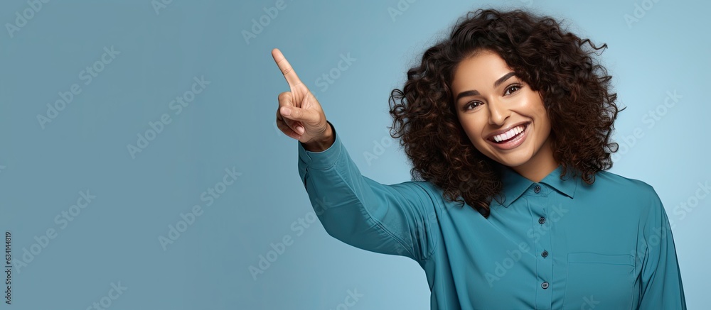 Poster Happy Hispanic woman pointing enthusiastically with both hands showcasing an object in the available space