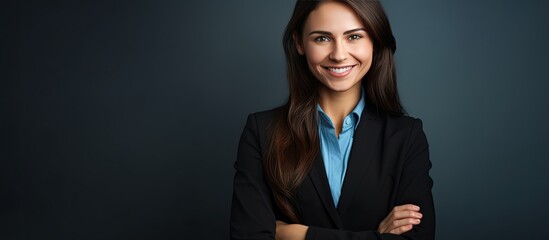 Studio portrait of a smiling businesswoman with folded arms against a plain background