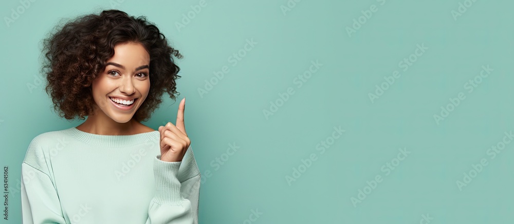 Poster Smiling cheerful Hispanic woman happily pointing to side and upwards displaying object in empty area