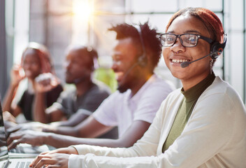 Smiling beautiful African American woman working in call center with diverse team