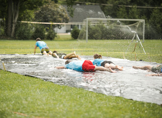 Kids play with water, boy swimming in soap bubbles. Summer garden outdoor fun for children. Boy...