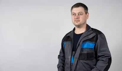 Portrait of a man in working overalls on a white background.