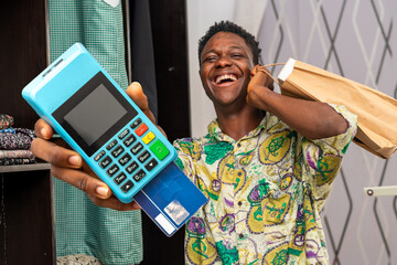 African delivery man holding pos and shopping bag