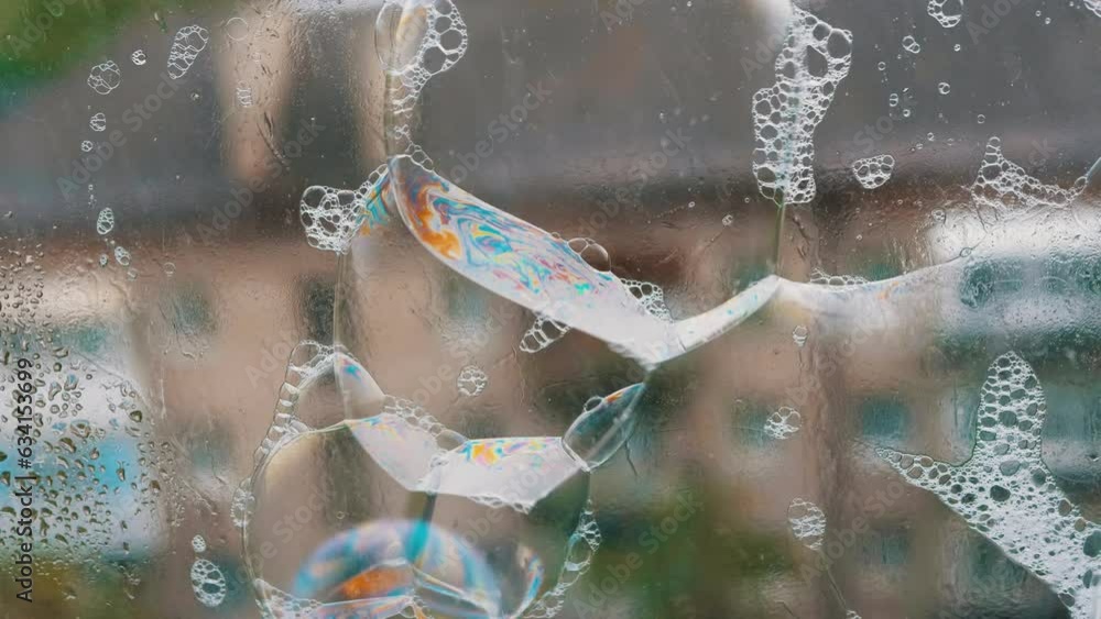 Poster lots of sticky multicolored soap bubbles on the surface of a wet rainy window. blowing soap rainbow 