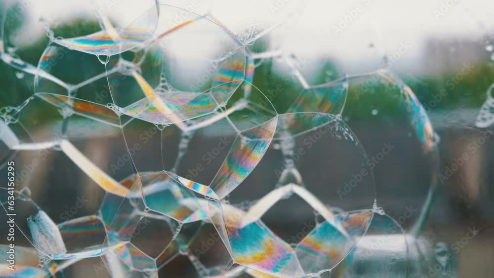 Poster lots of sticky multicolored soap bubbles on the surface of a wet rainy window. blowing soap rainbow 