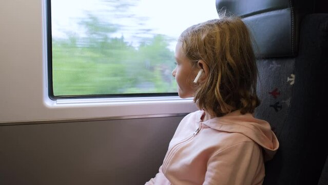 Little girl looking through a window in Mass Rapid Transit (MRT) train. Public transport and family travel concept